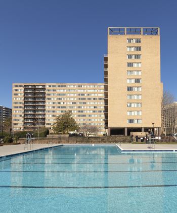 A large building with a pool in front of it.